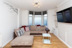 a living room with a couch and a tv at The White & Warm, Free Parking & Wifi, 8 beds in Colchester