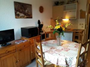 a kitchen with a table with a vase of flowers on it at Combe Blanche 1309 in Manigod