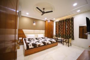 1 dormitorio con 1 cama y ventilador de techo en Hotel Royal Phoenix en Agra