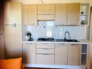 une cuisine avec des armoires en bois et un évier dans l'établissement Residenze Zodiaco, à Santa Teresa Gallura