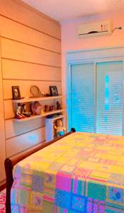 ein Schlafzimmer mit einem farbenfrohen Bett und einem Fenster in der Unterkunft Casa em Avaré ao lado da Represa do Jurumirim in Palmeiras