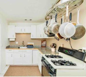 uma cozinha com fogão e algumas panelas e frigideiras em Misha’s Hunn Cottage em Yuba City