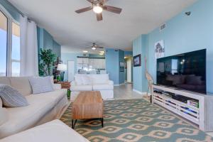 a living room with a white couch and a flat screen tv at Oceanfront Corner-Unit Condo on Perdido Key! in Pensacola