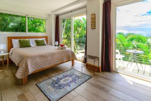 sypialnia z łóżkiem i dużym oknem w obiekcie Funky Monkey Lodge w mieście Playa Santa Teresa