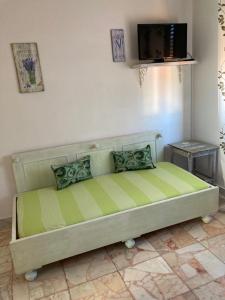 Cama verde en habitación con TV en finestra tra cielo e mare en Luni