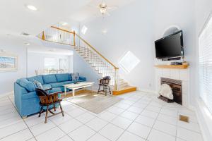 a living room with a blue couch and a fireplace at Jenny Lind East - Nordic Villas in Orange Beach