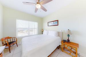 a bedroom with a white bed and a ceiling fan at Jenny Lind East - Nordic Villas in Orange Beach