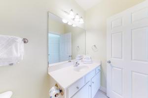 a white bathroom with a sink and a mirror at Jenny Lind East - Nordic Villas in Orange Beach +25 photos