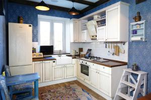 2 Rooms VIP Apartment on Sobornyi 216 في زاباروجيا: مطبخ مع الأجهزة البيضاء والجدران الزرقاء