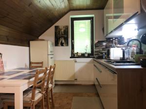a kitchen with a table and a white refrigerator at SavaDolinka House in Mojstrana