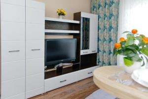 a living room with a tv in a white cabinet at Прекрасная студия ЖК Академ-Риверсайд. in Chelyabinsk