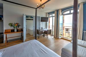 a hotel room with a bed and a desk and a room at Hotel Le Rayon Vert in Étretat