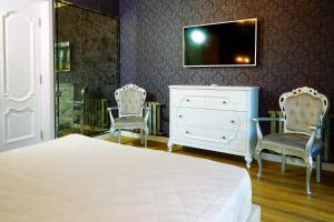 een slaapkamer met een bed, 2 stoelen en een dressoir bij 2 Rooms VIP Apartment on Sobornyi 216 in Zaporozhye