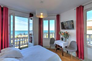 a bedroom with a bed and a view of the ocean at Hotel Le Rayon Vert in Étretat