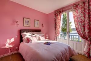 a bedroom with pink walls and a bed with a window at Les Eaux qui Rient in Sanguinet