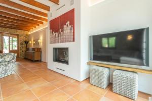 ein Wohnzimmer mit einem Flachbild-TV und einem Kamin in der Unterkunft Saran in Llucmajor