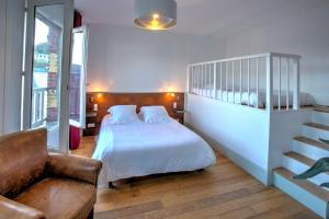 a bedroom with a bed and a couch and a chair at Hotel Le Rayon Vert in Étretat