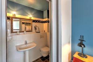 a bathroom with a sink and a toilet at Hotel Le Rayon Vert in Étretat