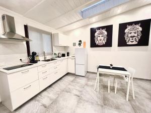a kitchen with white cabinets and a white table at Real suite spa in Palermo