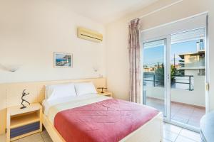 a bedroom with a bed and a balcony at Anna Αpartments II in Agia Marina Nea Kydonias