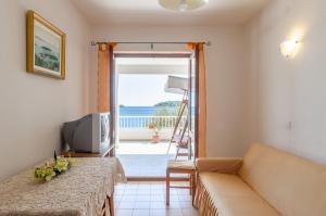 a living room with a couch and a view of the ocean at Apartmani Srdjana in Prizba