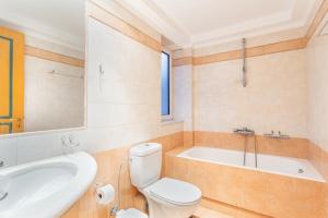 a bathroom with a toilet and a tub and a sink at Anna Αpartments II in Agia Marina Nea Kydonias +25 photos