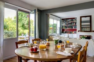 a dining room with a wooden table with fruit on it at Les Eaux qui Rient in Sanguinet