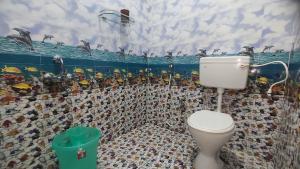 een badkamer met een toilet en een muurschildering van pinguïns bij Sumithra Apartment in Pondicherry +27 foto's
