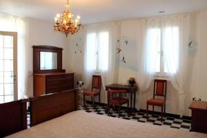 Zimmer mit einem Tisch, Stühlen und einem Kronleuchter in der Unterkunft Re Piano appartamento Le Rondini in Modigliana