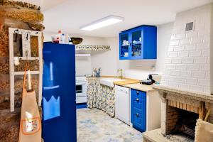 a kitchen with blue cabinets and a blue refrigerator at A Casa Alegre in Miranda do Douro