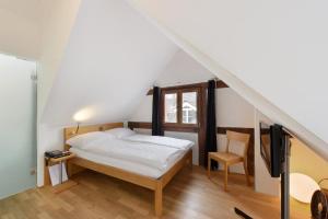a bedroom with a bed and a tv in a attic at Hotel Lestelle - self check-in in Lucerne
