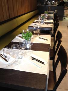 a row of tables with wine glasses and napkins at Hotel Lestelle - self check-in in Lucerne