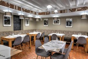 a dining room with tables and chairs and a chalkboard at Hotel Le Rayon Vert in Étretat