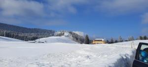 a snow covered field with a building in the background at Antico Maso in Lavarone