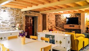 sala de estar con mesa blanca y sillas amarillas en A Casa Alegre, en Miranda do Douro
