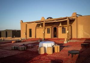 un edificio con un tavolo bianco davanti di Mhamid Luxury Camp Experience a M'Hamid Altre 37 foto