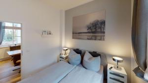 a bedroom with a bed with blue pillows on it at Lieblingsapartment No.3 mit 2 Schlafzimmern in Top City-Lage in Rostock