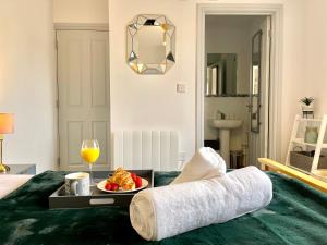 Una cama con una bandeja de comida y una copa de vino. en Stylish Cosy and Bright Apartment - Fantastic Location - Perfect for Business or solo travellers en Bishops Stortford