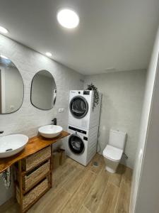 a bathroom with a washing machine and a toilet at Precioso Apartamento recién reformado en centro in Aranjuez