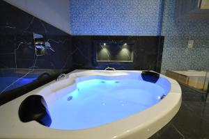 a bath tub in a bathroom with a blue at Pousada Chão de Folhas SPA Boutique in Águas de Lindoia +38 photos