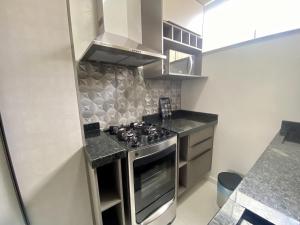 a kitchen with a stainless steel stove top oven at Dona Olivia Residencial in Vitória da Conquista