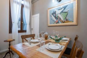 a dining room table with plates and glasses on it at Apartment Sisila in Venice