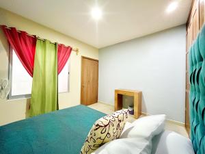 um quarto com uma cama azul e cortinas vermelhas em Gallery Home em Ocotlán