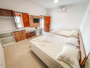 a bedroom with two beds and a desk in it at Pousada Vasto Horizonte in Barreirinhas +25 photos