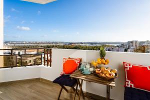 einen Balkon mit einem Tisch und einer Obstschale darauf in der Unterkunft stylish apartment with marina view and aircon in Portimão