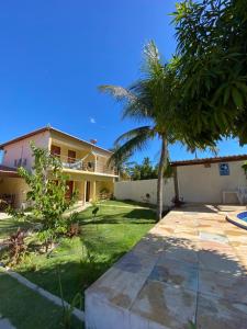 a house with a palm tree in the yard at Pousada Villa Manduca in Amontada