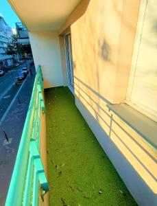 a balcony with a green railing on a building at Lovely flat nearby Paris fully redone with free parking on premises and balcony in Clichy