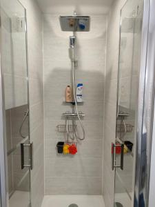 a bathroom with a shower with a glass door at Lovely flat nearby Paris fully redone with free parking on premises and balcony in Clichy