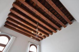 a wooden ceiling in a room with two windows at Apartment Sisila in Venice