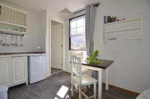 a kitchen with a table and a chair and a window at Casa El Patio in Hermigua